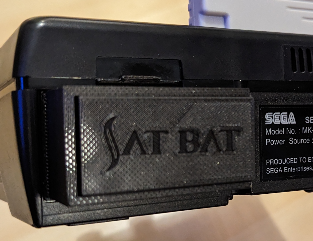 The back of a Sega Saturn, showing off the accessory The SatBat
